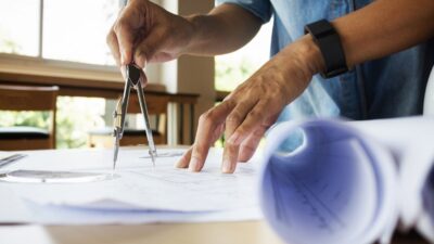 hands of an engineer working on a construction blueprint for a project