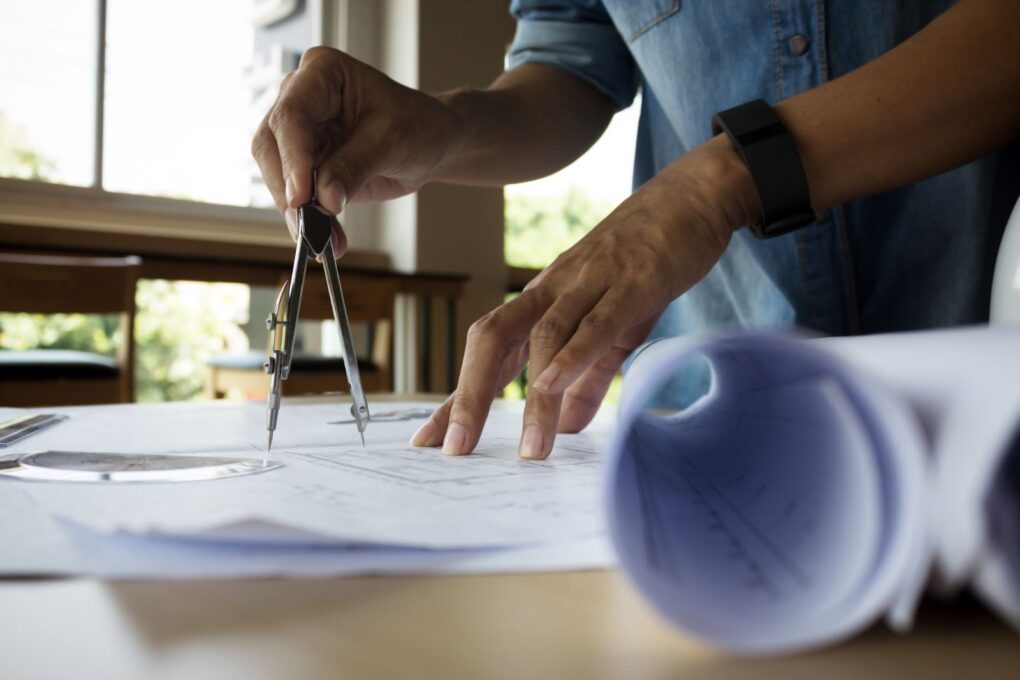 Hands of engineer working on blueprint