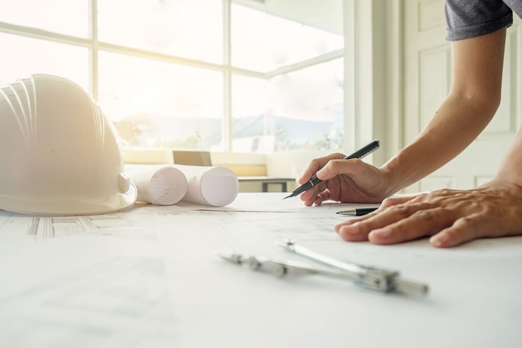 Hands of engineer working on blueprint